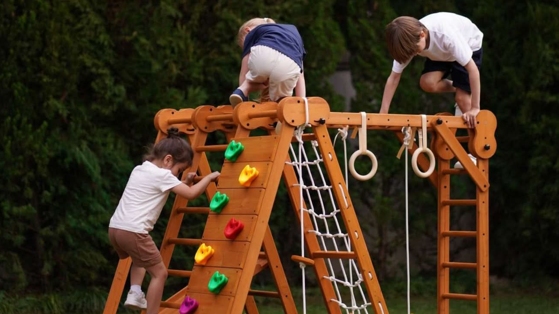 Toddler going down the slide of the Avenlur Chestnut indoor/outdoor jungle gym in the backyard