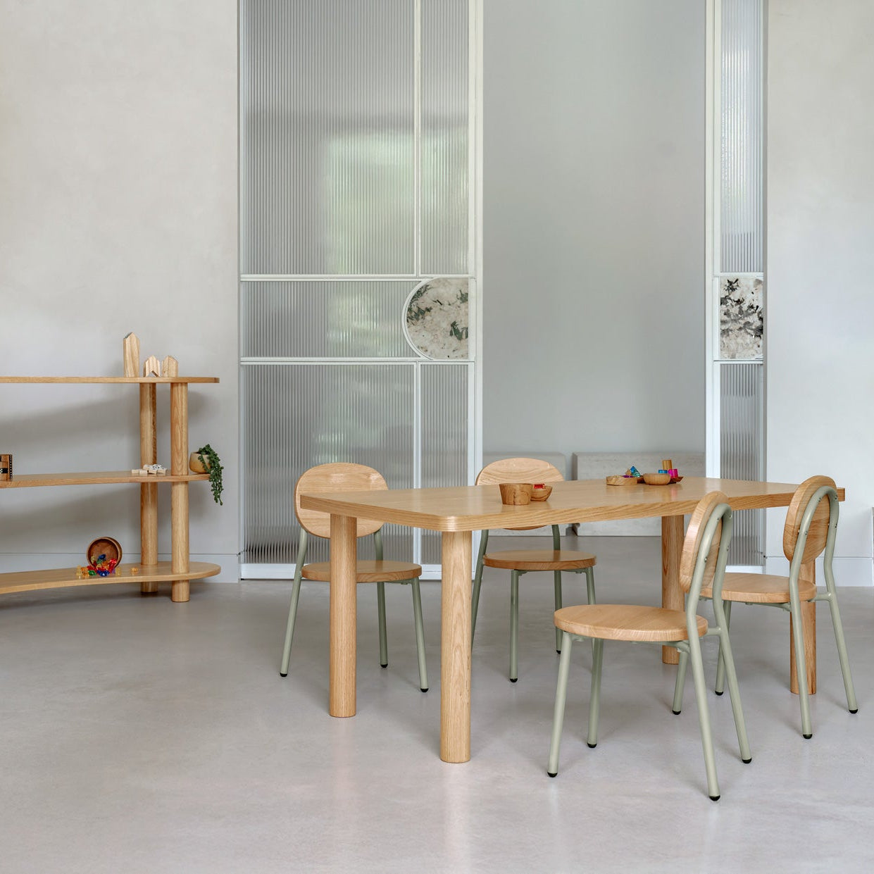 Modern dining area with wooden table and chairs in a minimalistic room.