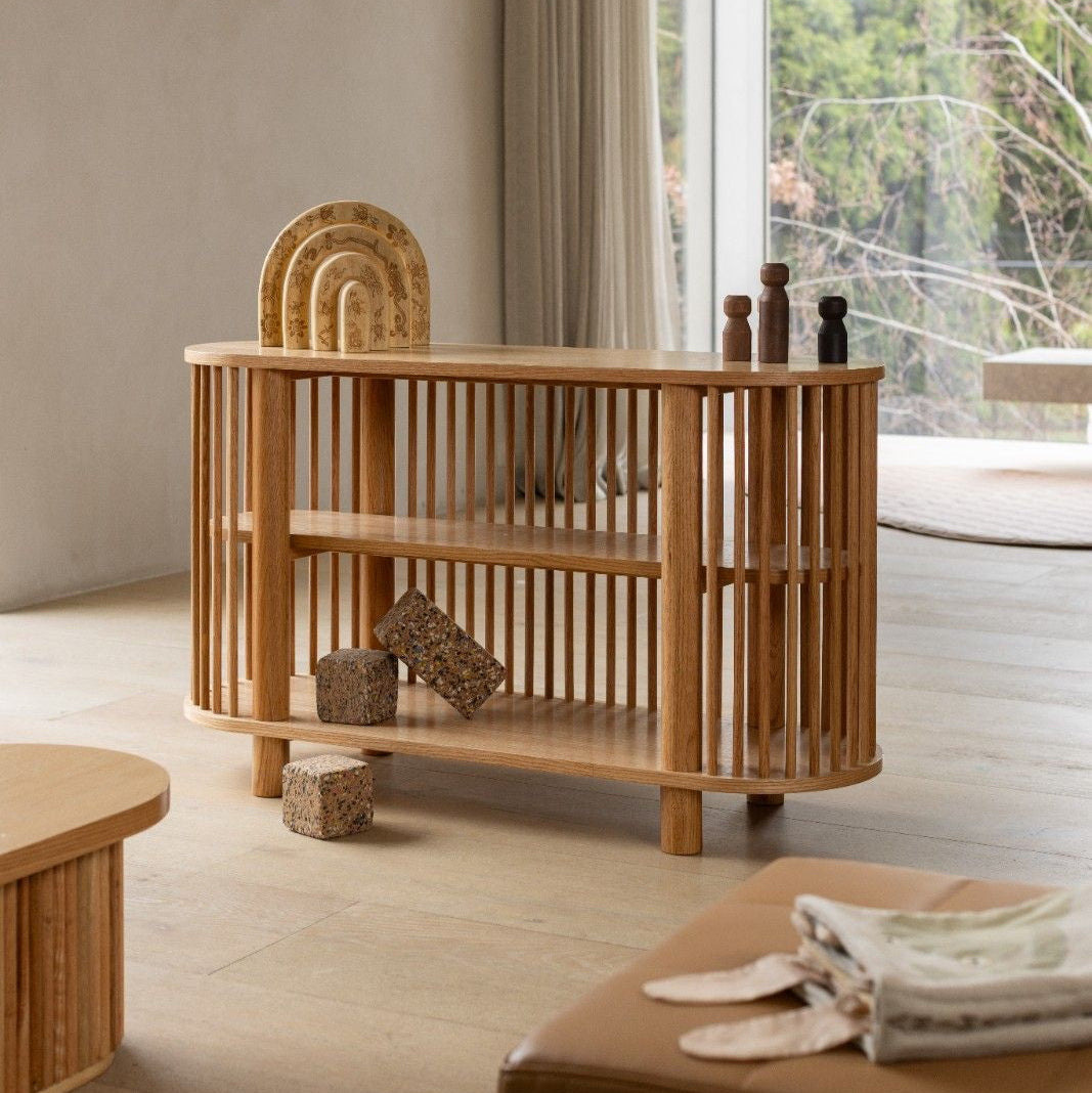 Wooden crib in a room with large windows and neutral decor