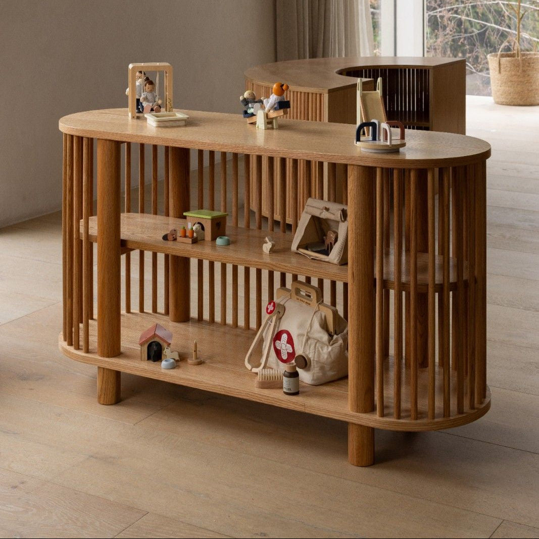 Wooden shelf with decorative items in a room with large windows.