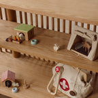 Wooden shelf with toys and a bag on a wooden floor