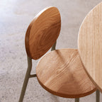 Wooden chairs with round seats on a light-colored floor.