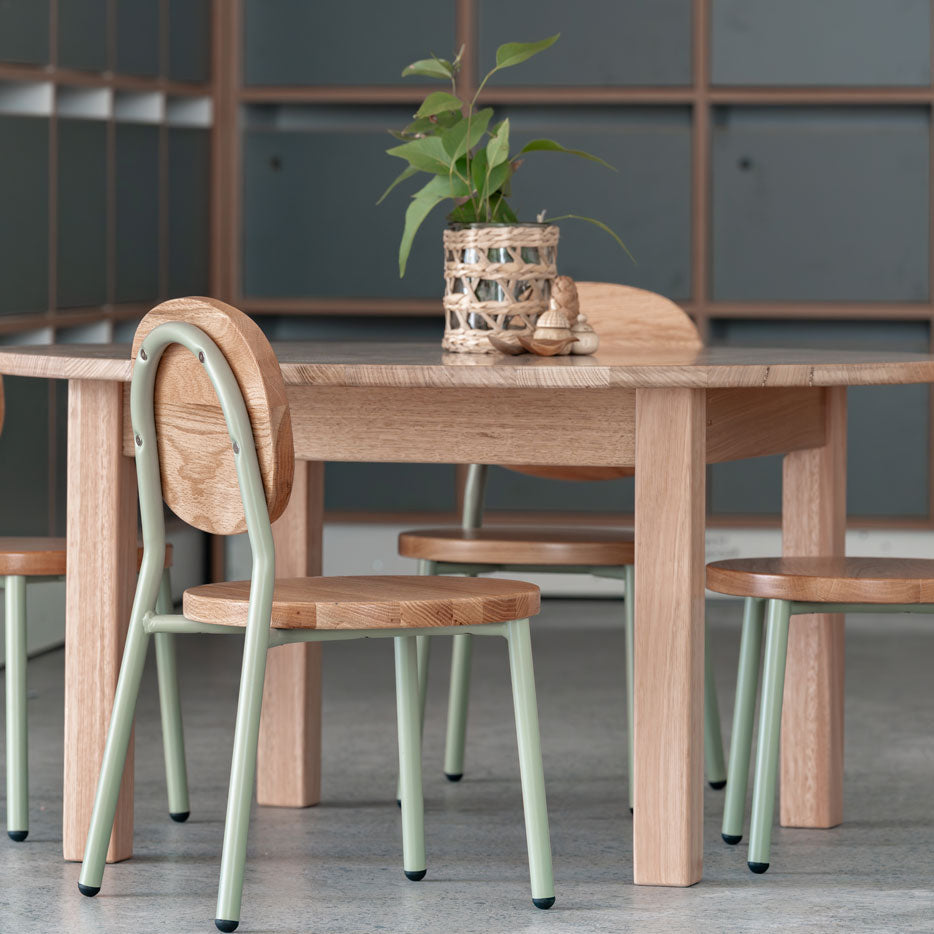 Dining table with chairs in a room with gray walls and shelves.