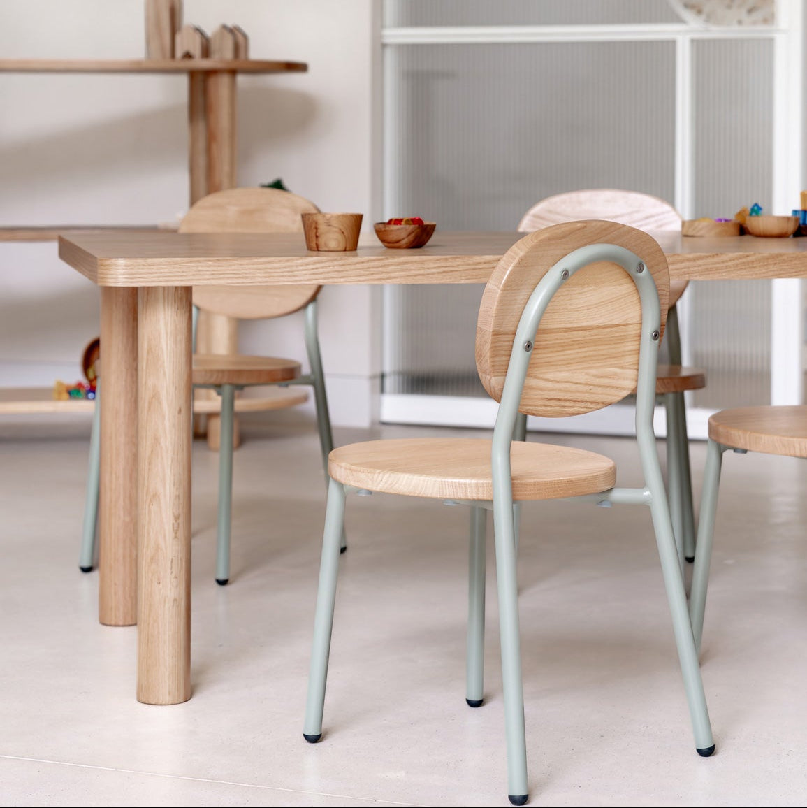 Dining area with wooden tables and chairs in a minimalistic setting