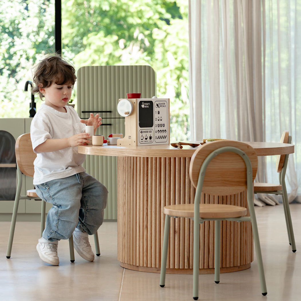 Child playing with toy kitchen set in a modern kitchen
