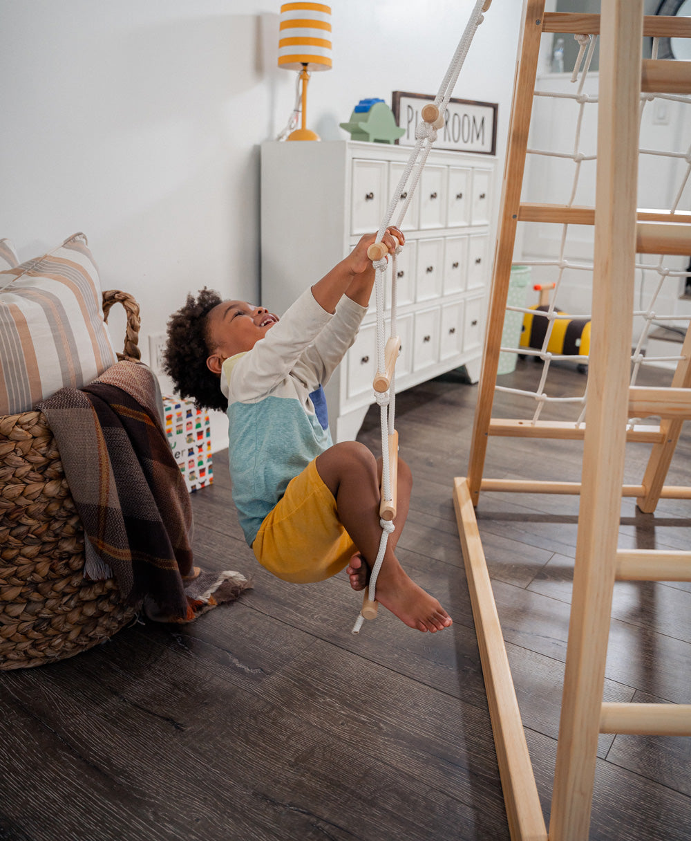 Child Playing on Rope Ladder of Avenlur's Magnolia Natural Color Real Wood Playset in Playroom