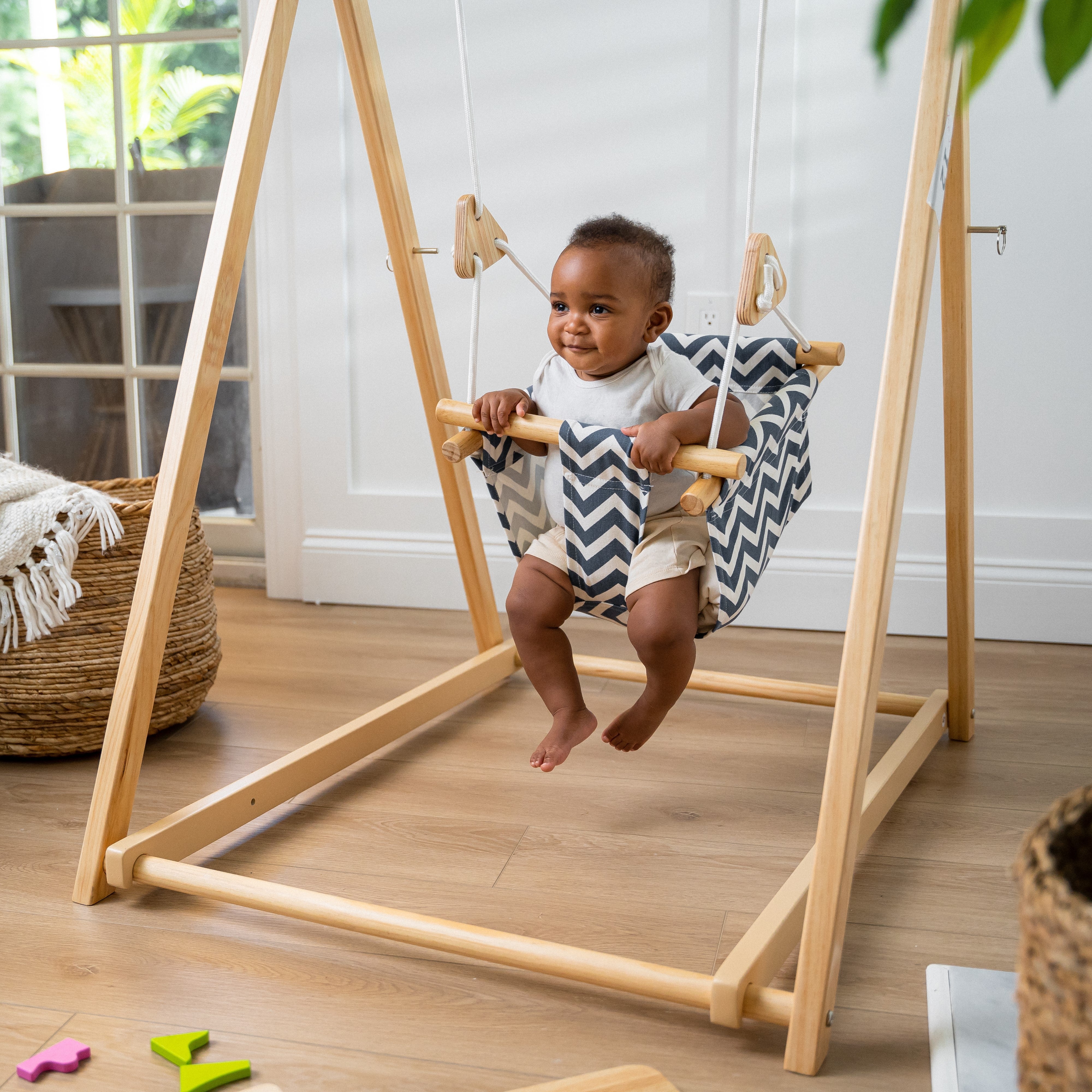 Baby in the Avenlur Spruce foldable wooden indoor swing with stand