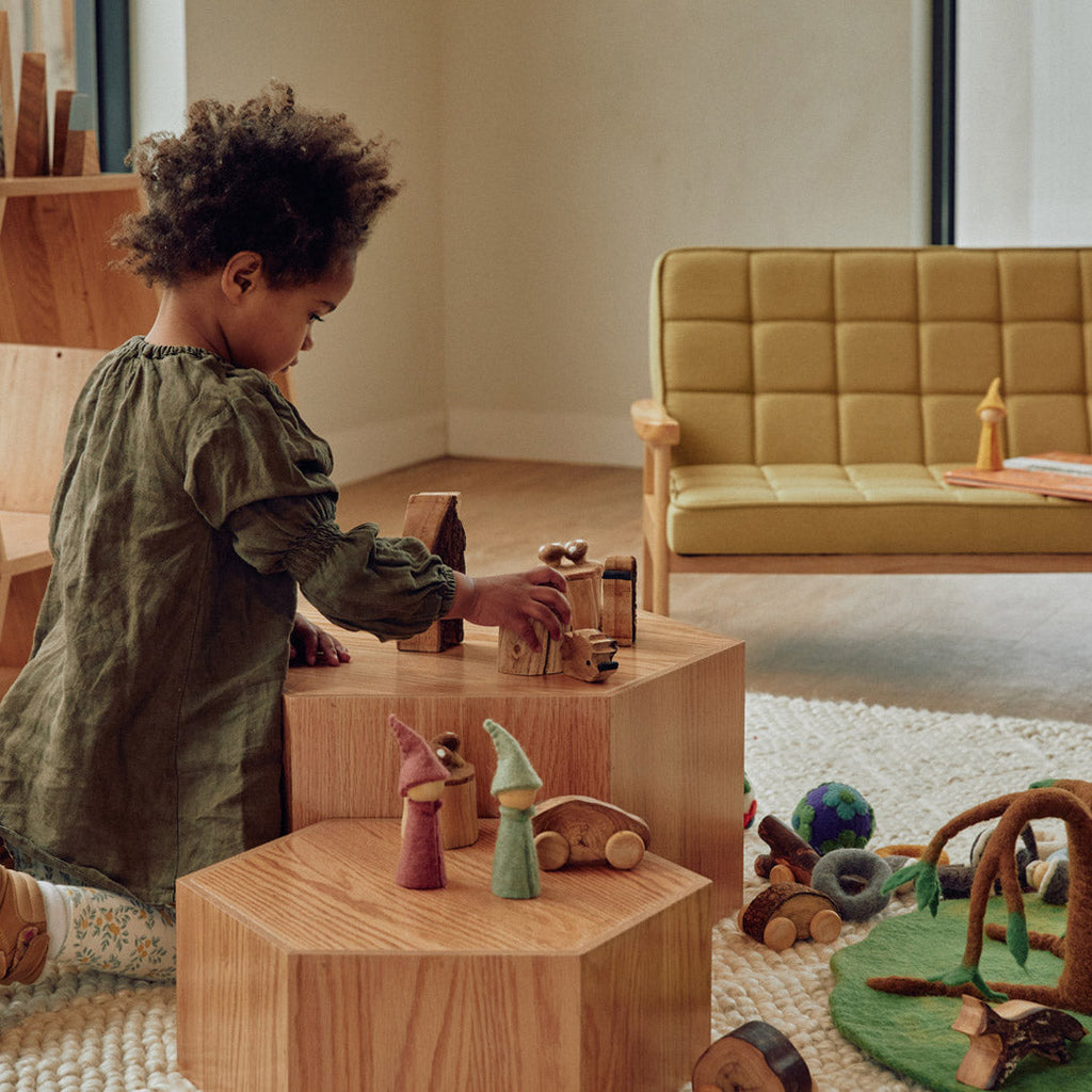 Child playing with wooden toys in a modern living room