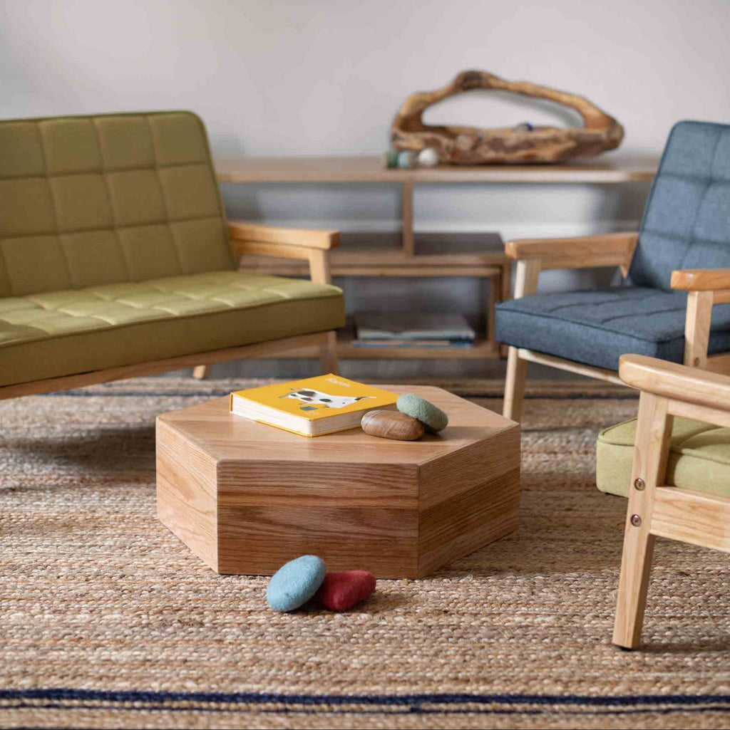 Modern living room with green sofa, blue armchair, and wooden coffee table.