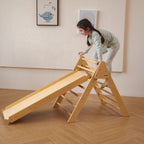 Toddler sliding down the Avenlur Bazel Pikler slide ramp