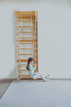 Kids playing on the Avenlur Betula wooden wall ladder at home