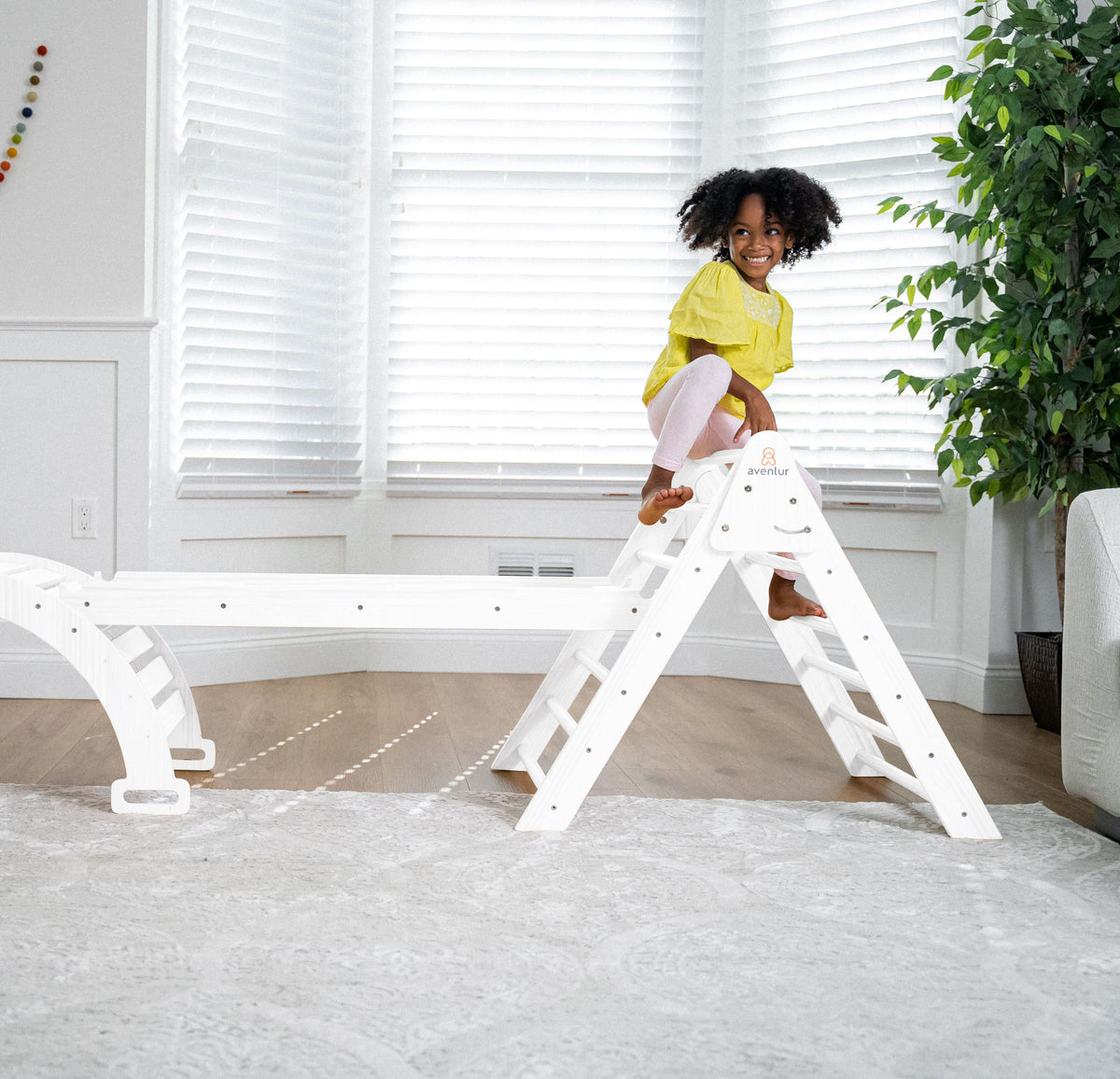 Toddler balancing on the Avenlur Hazel rocker