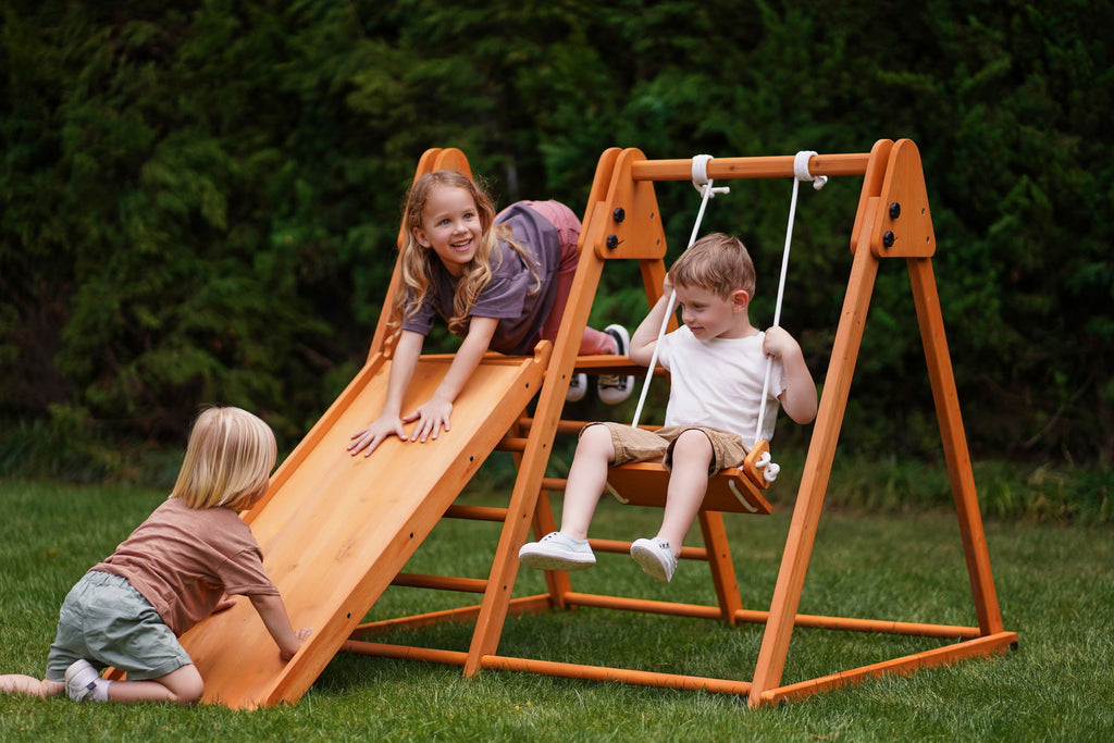 Toddler climbing the Avenlur Juniper backyard climber on the grass