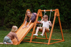 Toddler climbing the Avenlur Juniper backyard climber on the grass