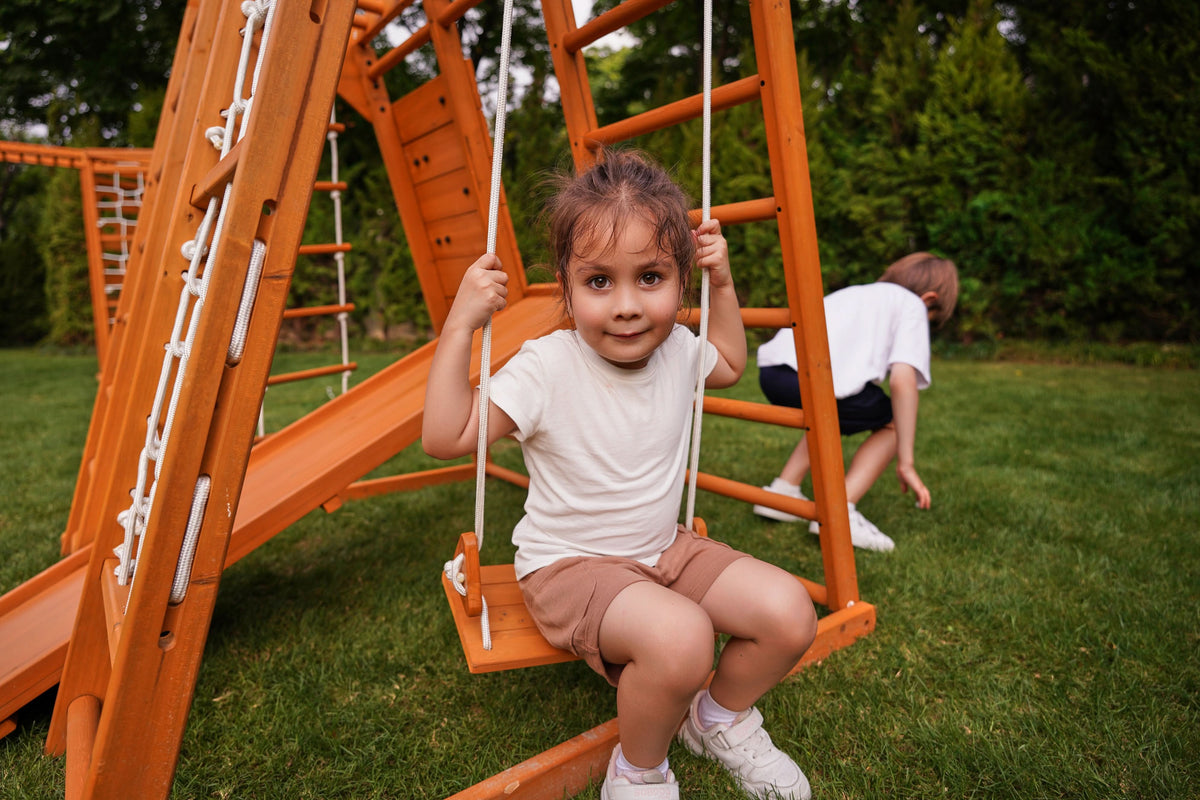 Kids climbing the Avenlur Magnolia outdoor climbing structure