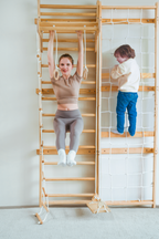 Avenlur Neem rope climbing wall for kids next to a wooden wall ladder