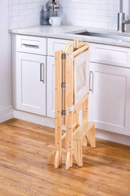 Toddler on the Avenlur Plum toddler kitchen stool helping with dinner