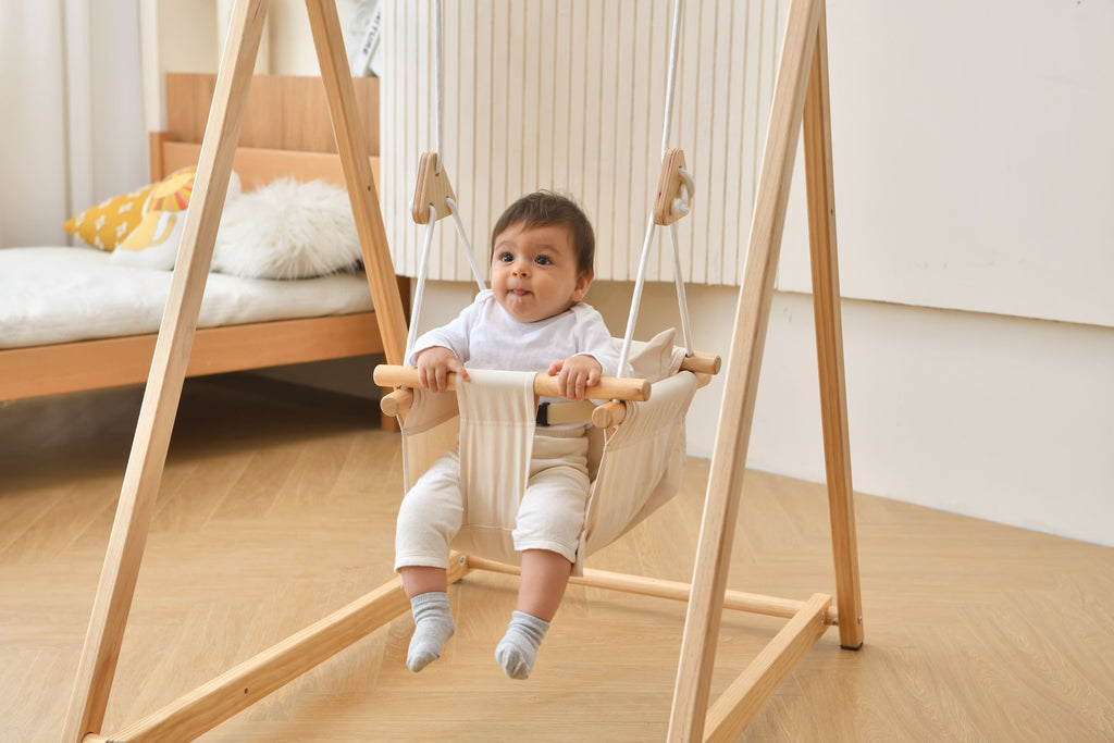 Toddler swinging in the Avenlur Spruce swing in the living room