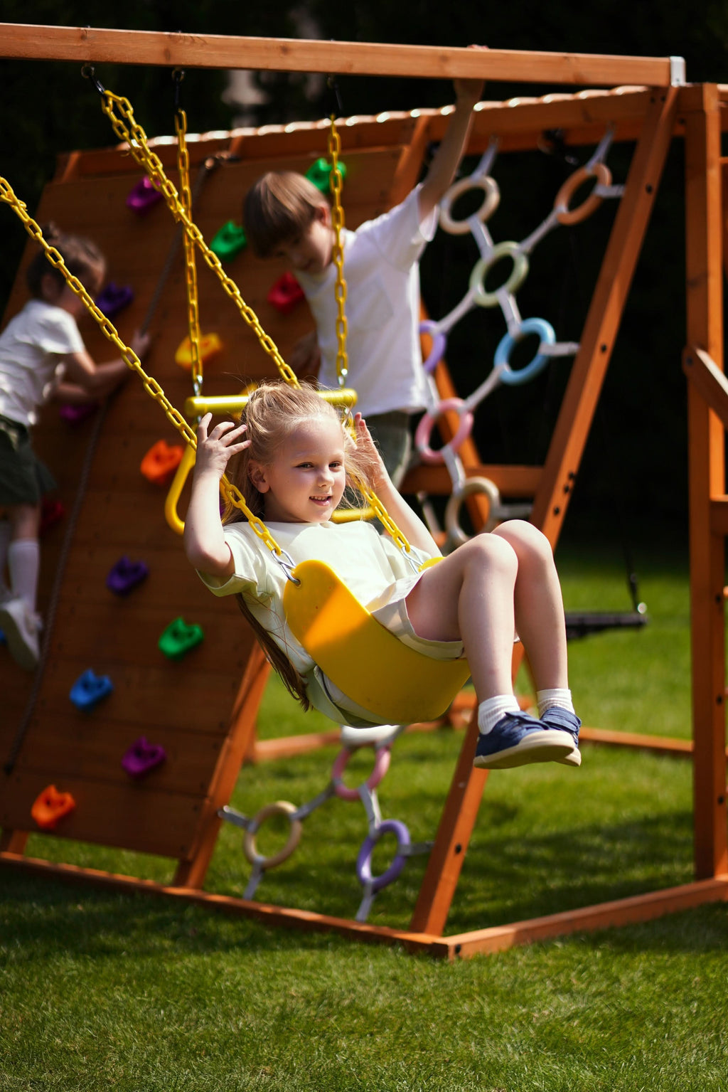 Trapeze bar and belt swings on the Avenlur Sycamore Jumbo backyard jungle gym for kids