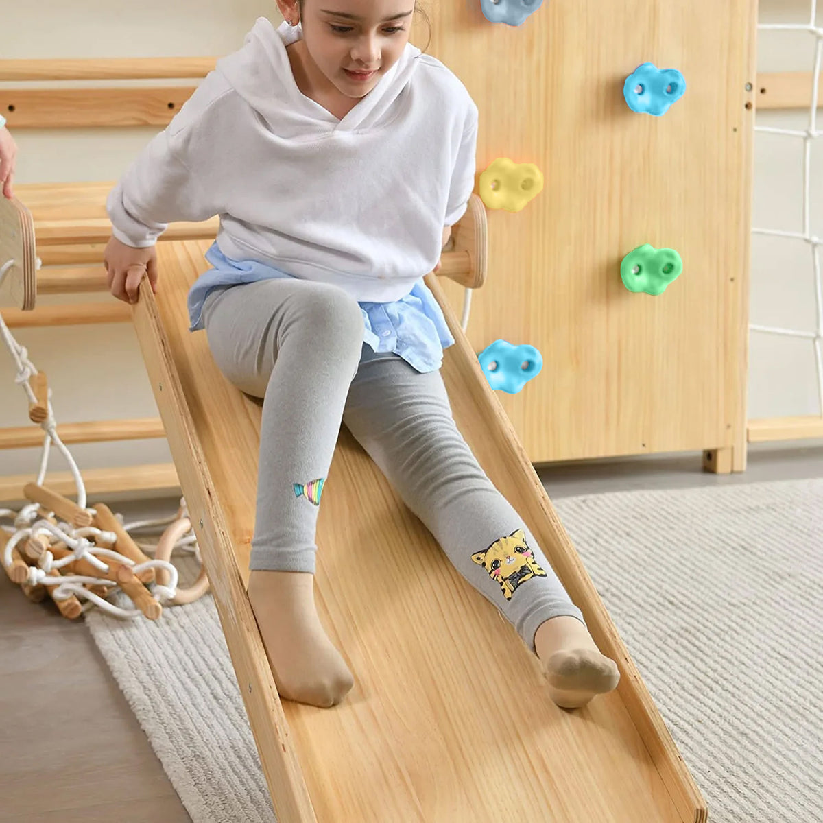 Child sliding down the Avenlur Walnut indoor jungle gym slide