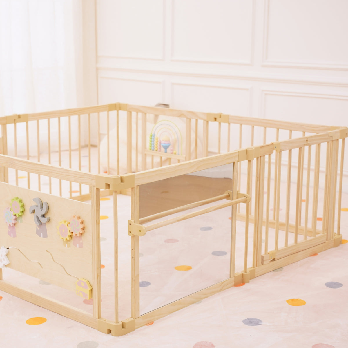Baby standing at the shatter-resistant mirror and safety bar on the Avenlur wooden playpen