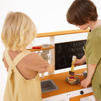 Kids pretend cooking together at the Avenlur Woodland mud kitchen