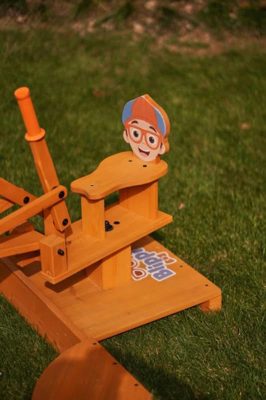 Child playing with the Blippi excavator in summer