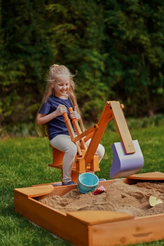 Two kids taking turns on the Blippi excavator
