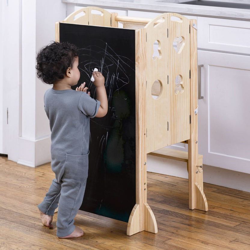 Toddler helping prepare food at the counter from an Avenlur kitchen tower