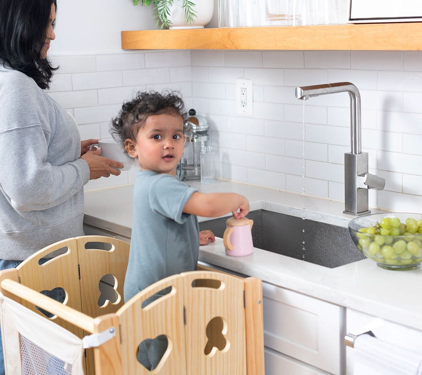 Child standing inside the Avenlur Laurel kitchen tower with safety rails on every side