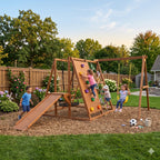 Kids on the rock climbing wall and ring ladder of the Sycamore XL jungle gym