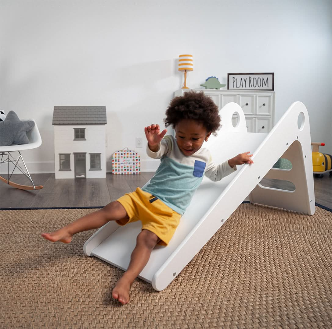 Child Sliding Down Manuka - Avenlur's Safe and Fun Indoor Toddler Slide in Playroom. Shown in White