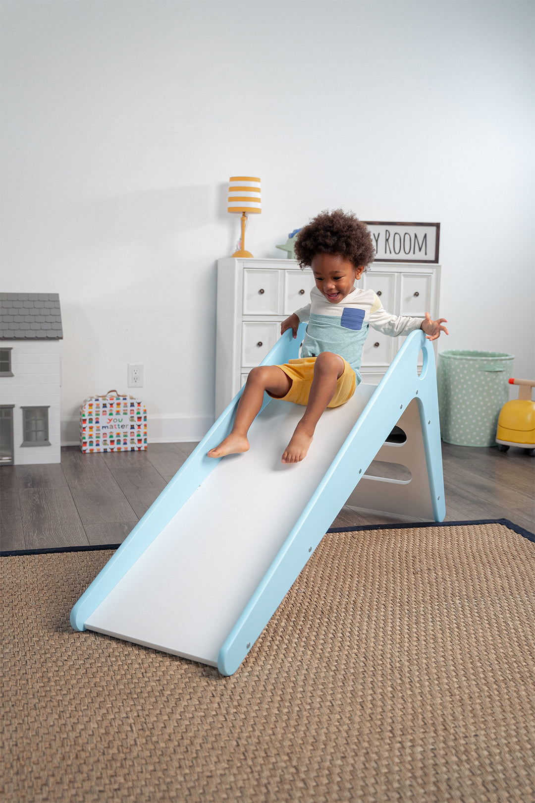 Toddler Sliding Down Manuka - Avenlur's Safe and Fun Indoor Toddler Slide in Playroom. Shown in Blue.