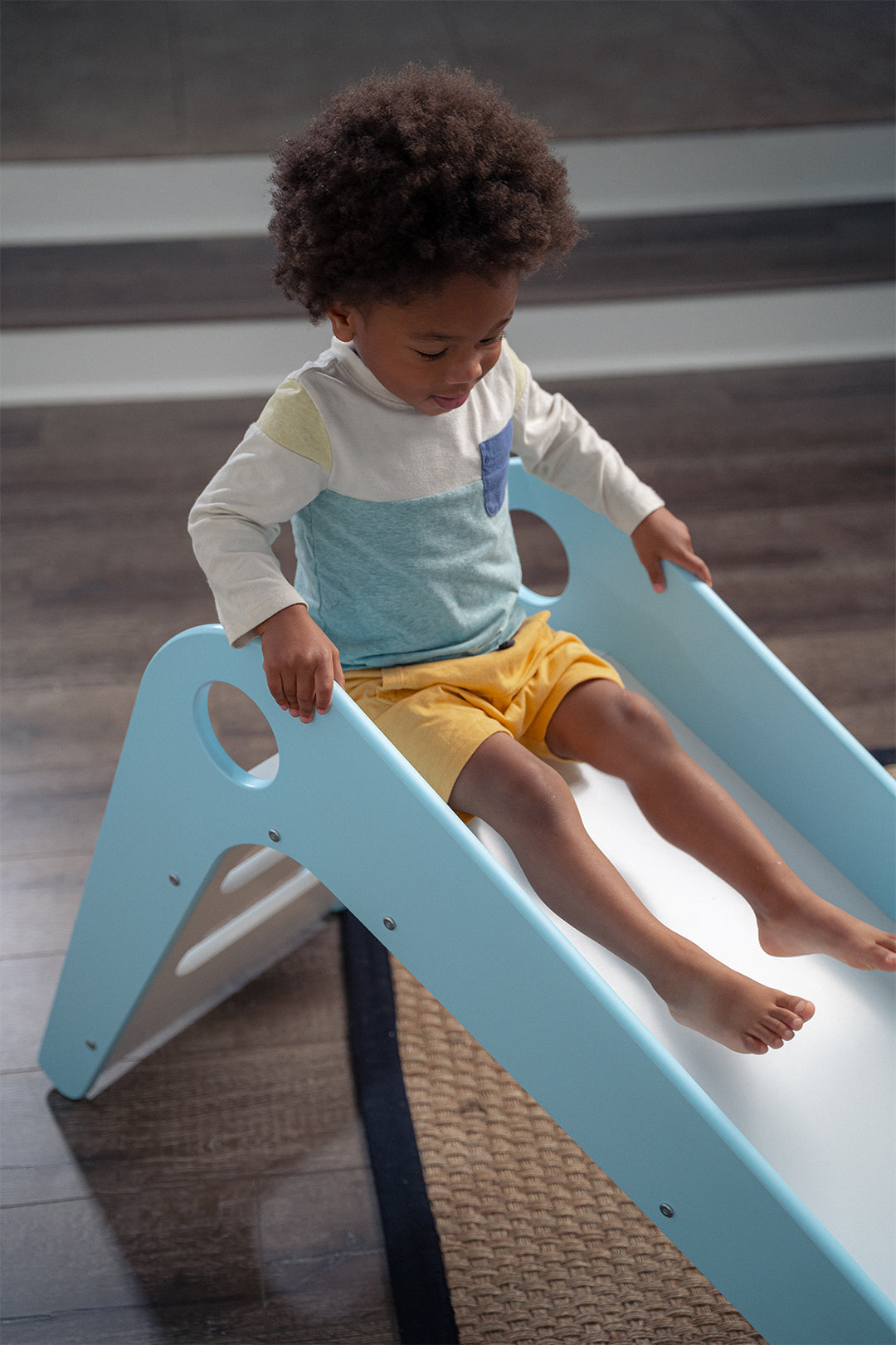 Child Sitting on Manuka - Avenlur's Safe and Fun Indoor Toddler Slide. Shown in Blue