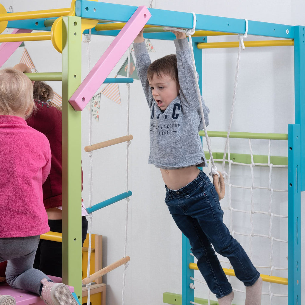 Avenlur Grove rainbow indoor gym for kids mounted to the wall with slide and monkey bars