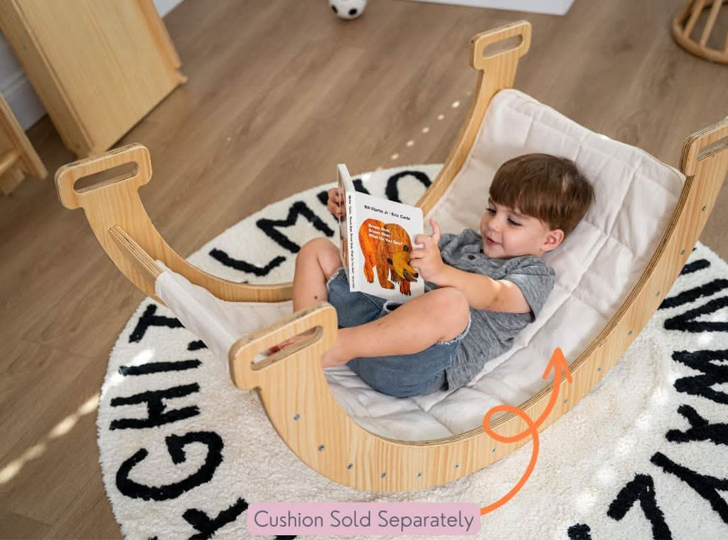 oddler reading in Avenlur Hazel Rocker with cushion insert on alphabet rug – cushion sold separately