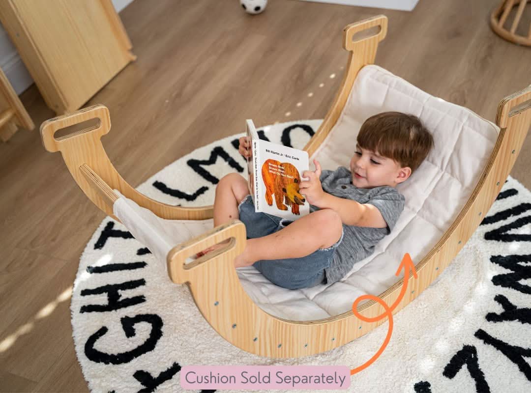 oddler reading in Avenlur Hazel Rocker with cushion insert on alphabet rug – cushion sold separately