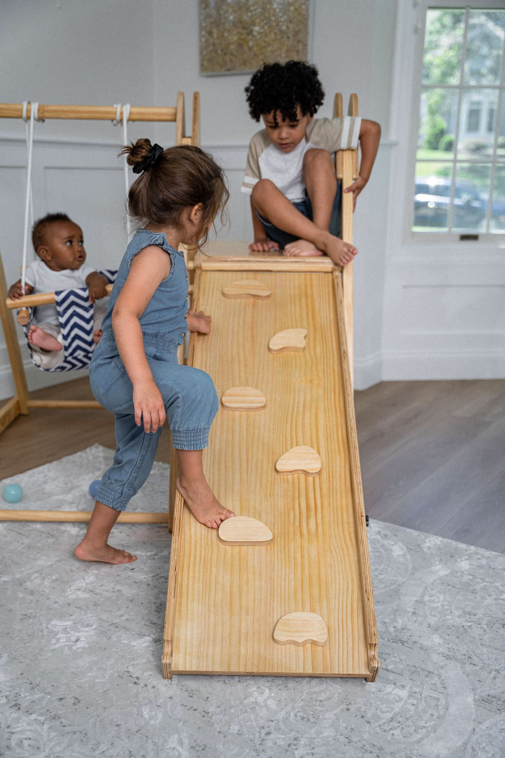 Toddler playing on the Avenlur Juniper indoor toddler gym