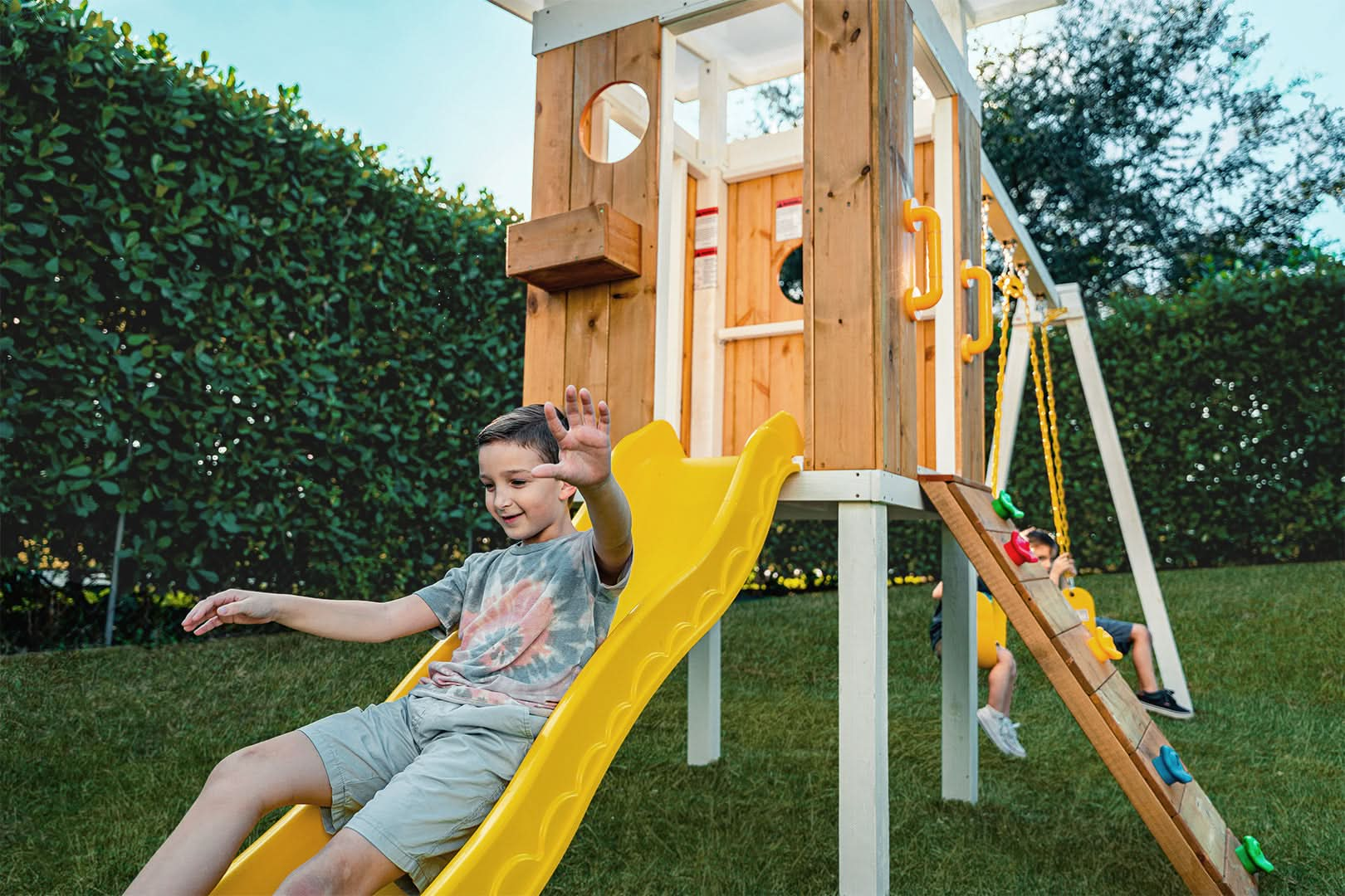 Boy Sliding Down Slide of Avenlur's Forrest Swing Set